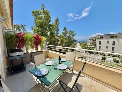 a patio with a table and chairs on a balcony at Appartement Altu Mare 2 pièces avec terrasse AGOSTA PORTICCIO in Albitreccia