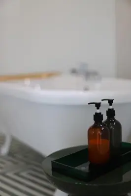 two bottles of soap on a green tray on a table at Villa Rétine in Ajaccio