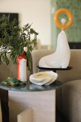 a table with a plate and vases on a couch at Villa Rétine in Ajaccio