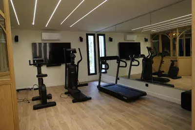 a gym with several tread machines in a room at Villa Rétine in Ajaccio