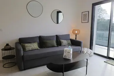 a living room with a couch and a table at A Macchia - T2 nature & couché de soleil in Figari