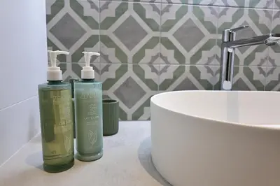 two bottles ofodorizers on a bathroom counter next to a sink at A Macchia - T2 nature & couché de soleil in Figari