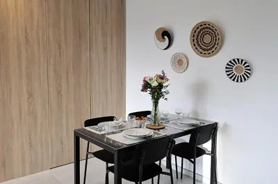 a table with black chairs and a vase of flowers on it at A Macchia - T2 nature & couché de soleil in Figari