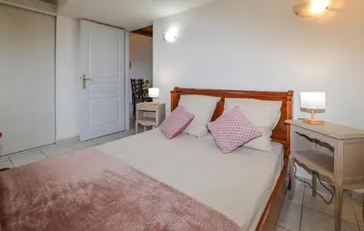 a bedroom with a bed with pink and white pillows at Cozy Apartment In Cuttoli With Wifi in Cuttoli-Corticchiato