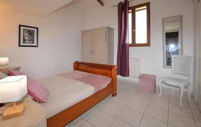 a bedroom with a bed and a table and a chair at Cozy Apartment In Cuttoli With Wifi in Cuttoli-Corticchiato