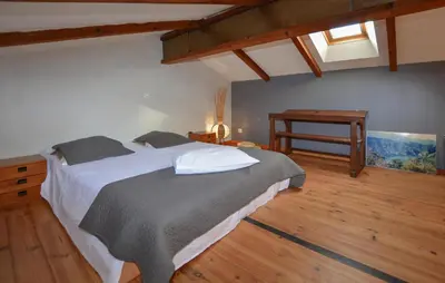 a bedroom with a large bed and a table at Cozy Apartment In Cuttoli With Wifi in Cuttoli-Corticchiato