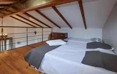 a large white bed in a room with wooden floors at Cozy Apartment In Cuttoli With Wifi in Cuttoli-Corticchiato