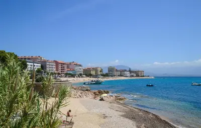 a beach with buildings and people on the water at Cozy Apartment In Cuttoli With Wifi in Cuttoli-Corticchiato