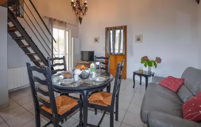 a dining room with a table and a couch at Cozy Apartment In Cuttoli With Wifi in Cuttoli-Corticchiato