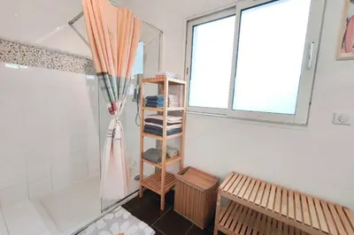 a bathroom with a shower and a shelf with an umbrella at Bright apartment in Albitreccia near beach in Albitreccia
