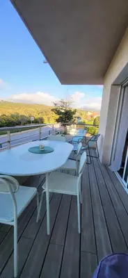 a row of tables and chairs on a wooden deck at Bright apartment in Albitreccia near beach in Albitreccia