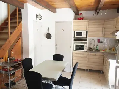 a kitchen with a table and chairs in a room at Pavillon au bord de la mer in Poggio-Mezzana