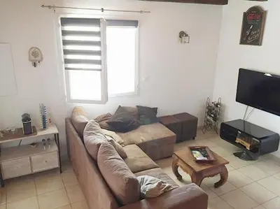 a living room with a couch and a table at Pavillon au bord de la mer in Poggio-Mezzana
