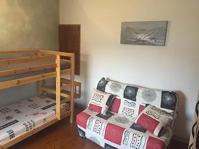 a room with a couch and a bunk bed at Pavillon au bord de la mer in Poggio-Mezzana
