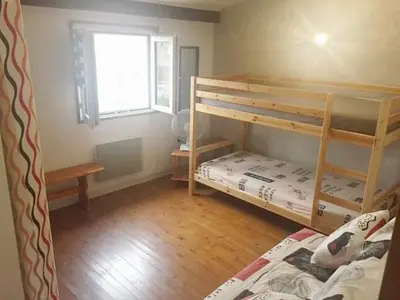 a bedroom with two bunk beds and a window at Pavillon au bord de la mer in Poggio-Mezzana
