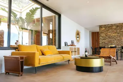 a living room with a yellow couch and a table at Villa petra mare in Cargèse