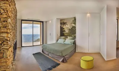 a bedroom with a bed with a view of the ocean at Villa petra mare in Cargèse