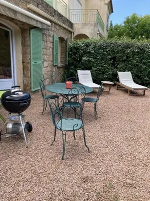 a patio with a table and chairs and a grill at A Casa Ghjalla in Cauro