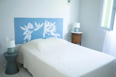 a bedroom with a white bed with a blue wall at A Casa Ghjalla in Cauro