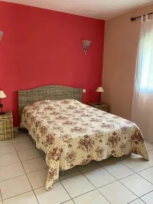 a bedroom with a bed and a red wall at A Casa Ghjalla in Cauro