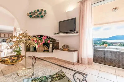 a living room with a fireplace and a tv at Villa de standing piscine- vue mer panoramique in Porto-Vecchio