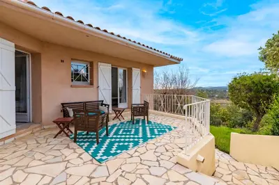 a patio of a house with a table and chairs at Villa de standing piscine- vue mer panoramique in Porto-Vecchio