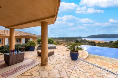 a patio with a view of the water at Villa de standing piscine- vue mer panoramique in Porto-Vecchio