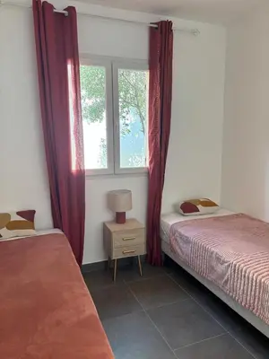 a bedroom with two beds and a window at Villa Tonnara - Maison du soleil in Sotta