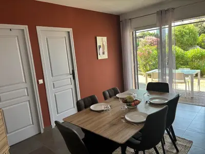 a dining room with a wooden table and chairs at Villa Tonnara - Maison du soleil in Sotta