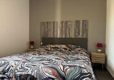 a bedroom with a bed and two lamps and two tables at Villa Tonnara - Maison du soleil in Sotta