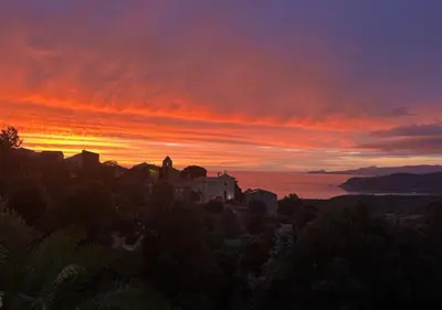 a sunset with a building on a hill at T3 neuf avec terrasse panoramique de 35m2 - Vue mer exceptionnelle in Villanova
