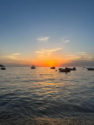 a sunset over the water with boats in the water at T3 neuf avec terrasse panoramique de 35m2 - Vue mer exceptionnelle in Villanova
