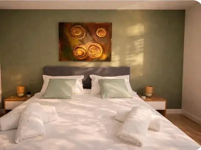 a bedroom with a white bed with a painting on the wall at Résidence Luna, Saint-Cyprien in Porto-Vecchio