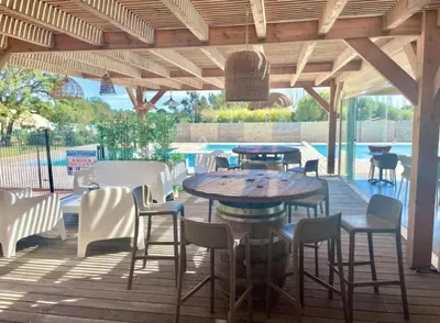 a patio with a table and chairs and a pool at Résidence Luna, Saint-Cyprien in Porto-Vecchio