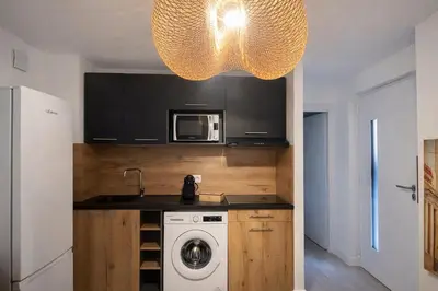 a kitchen with a washing machine and a chandelier at Résidence Luna, Saint-Cyprien in Porto-Vecchio