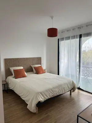 a bedroom with a large bed and a large window at Appartement T2 calme et paisible Vescovato in Venzolasca