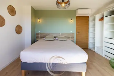 a bedroom with a large bed with white sheets at Villa Neuve Corse sud avec vue mer et piscine chauffée in Pianottoli-Caldarello