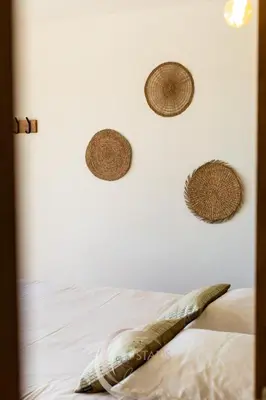 a bedroom with a bed with straw hats on the wall at Villa Neuve Corse sud avec vue mer et piscine chauffée in Pianottoli-Caldarello