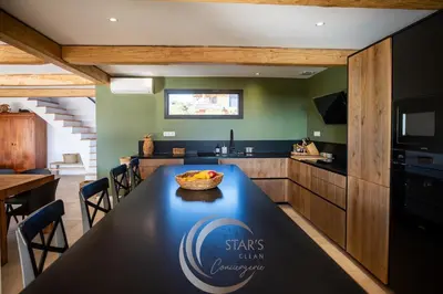 a kitchen with a table with a bowl of fruit on it at Villa Neuve Corse sud avec vue mer et piscine chauffée in Pianottoli-Caldarello