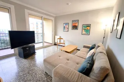 a living room with a couch and a flat screen tv at Bright apartment with balcony in Ajaccio in Ajaccio