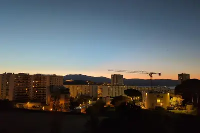 a view of a city at night with a crane at Bright apartment with balcony in Ajaccio in Ajaccio