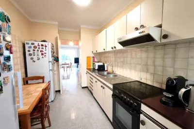 a kitchen with a refrigerator and a table in it at Bright apartment with balcony in Ajaccio in Ajaccio