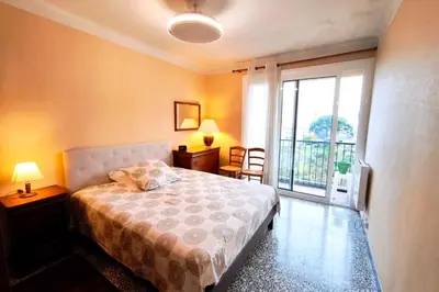 a bedroom with a bed and a large window at Bright apartment with balcony in Ajaccio in Ajaccio