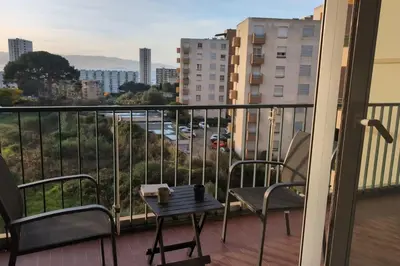 a table on a balcony with a view of a city at Bright apartment with balcony in Ajaccio in Ajaccio