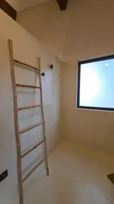 a room with a ladder next to a window at Villa Aria Natura, calme sérénité piscine chauffée in Porto-Vecchio
