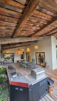 an outdoor kitchen and dining area of a house at Villa Aria Natura, calme sérénité piscine chauffée in Porto-Vecchio