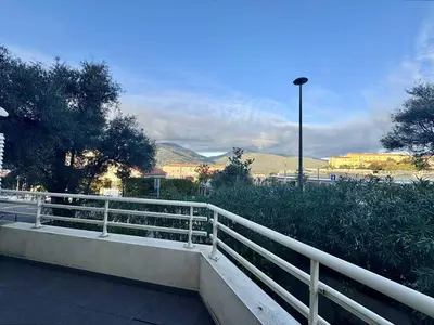 a white fence on a bridge with mountains in the background at T2 au cœur de Propriano in Propriano
