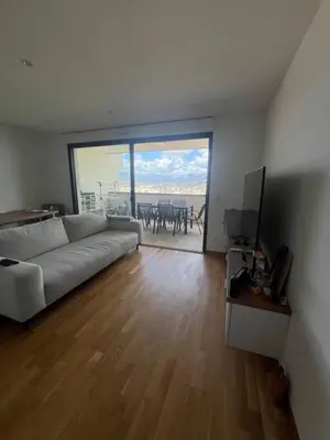 a living room with a white couch and a television at T2 avec vue panoramique in Ajaccio