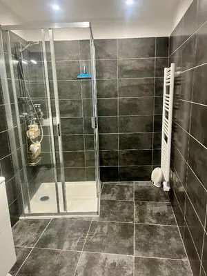 a shower with a glass door in a bathroom at T2 avec vue panoramique in Ajaccio
