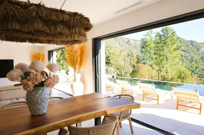 a dining room with a table and a large window at Villa Aberia Di Santa Lucia in Sainte-Lucie de Porto-Vecchio